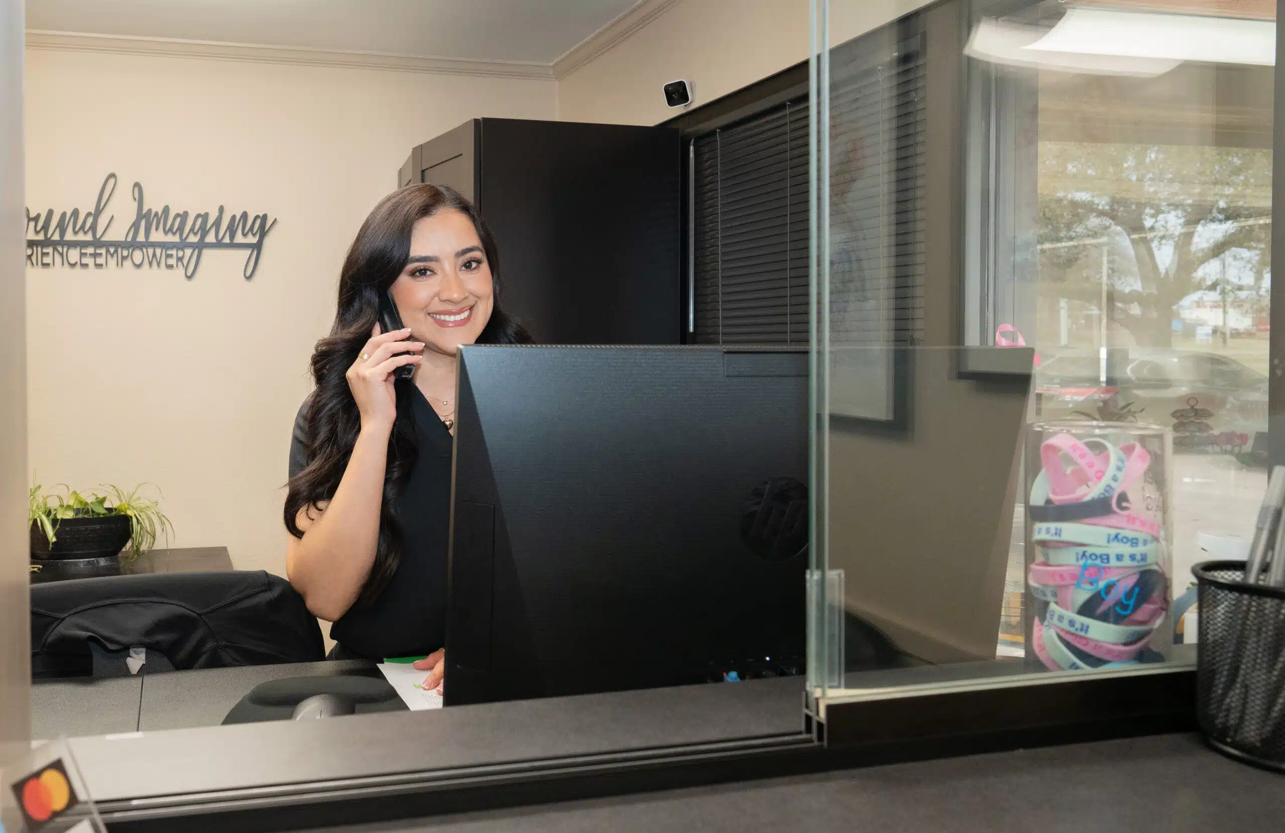 Front desk coordinator speaking on the phone while supporting mobile diagnostic ultrasound appointments